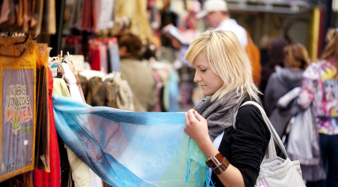 A participant explores a local market as part of her ethical consumerism project abroad. Woman learns about ethical consumerism on a trip abroad.